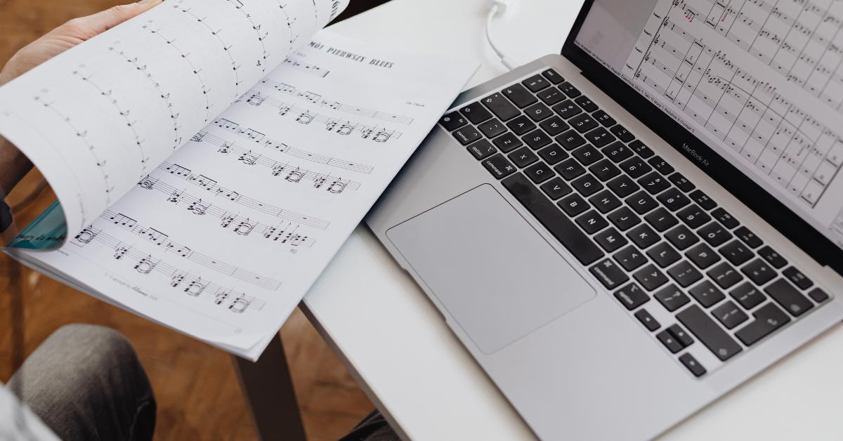 Spartito musicale aperto accanto a un laptop per lezioni di musica online