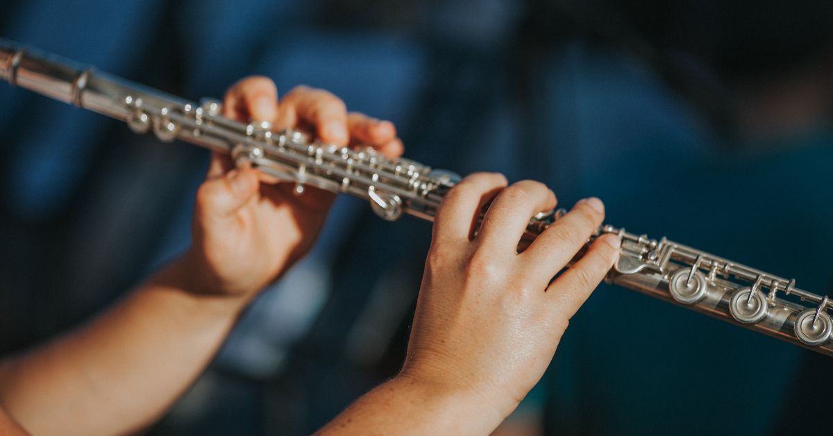 Mani che suonano il flauto traverso durante una lezione di tecnica musicale