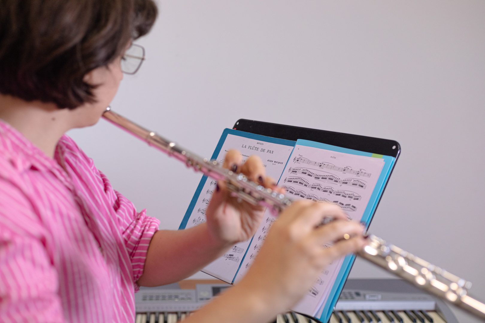 Insegnante di flauto che studia uno spartito durante una lezione di musica con approccio inclusivo e personalizzato